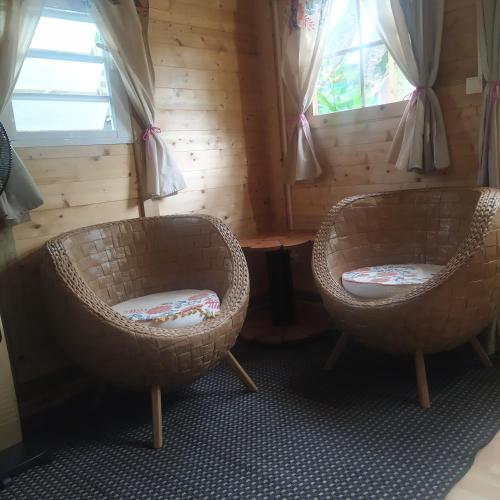 two chairs in a room with a table and windows at Ambalabaa in Saint-Philippe