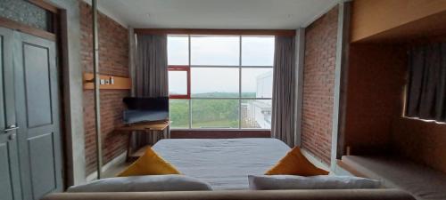 ein Schlafzimmer mit einem Bett und einem großen Fenster in der Unterkunft Kultur Pecatu Micro Villa in Uluwatu