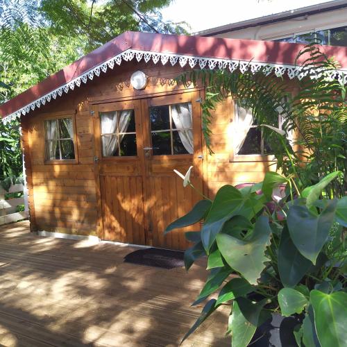 a wooden dog house with a red roof at Ambalabaa in Saint-Philippe