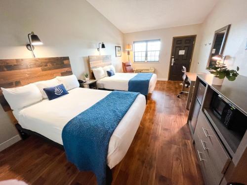 Saint ClairにあるPINEMARK Inn Suites Eventsのベッド2台、薄型テレビが備わるホテルルームです。