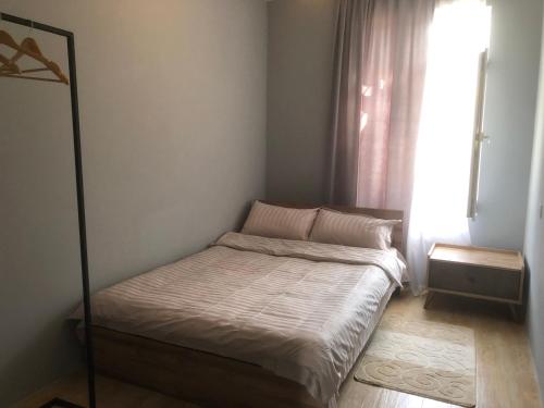 Una cama pequeña en una habitación con ventana. en Bubu's Home, en Batumi