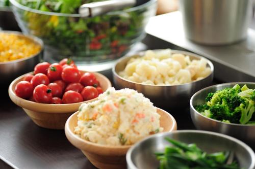 a table with bowls of different types of vegetables at Centurion Hotel&Spa Vintage Kobe in Kobe