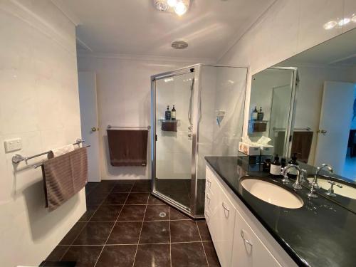 La salle de bains est pourvue d'un lavabo et d'une douche. dans l'établissement Port Lincoln Marina Waterfront Apartment, à Port Lincoln