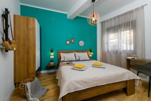 a bedroom with a large bed with a blue wall at Lounge house Dolce Vita in Pula