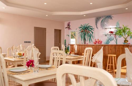 a dining room with wooden tables and white chairs at Somptua Garden in Ivato