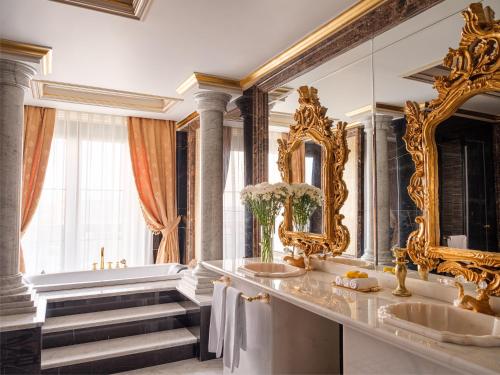 a bathroom with two sinks and a large mirror at Rixos Khadisha Shymkent in Shymkent