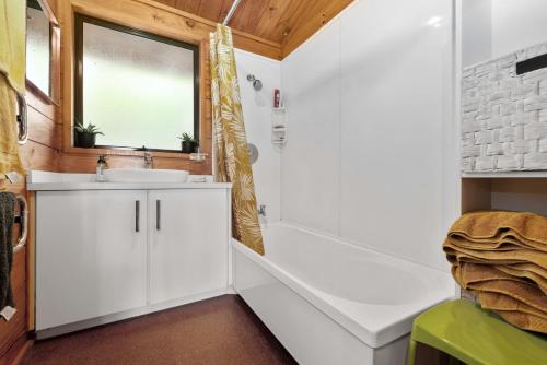 a bathroom with a shower and a sink at Rutherfurd Lakehouse - Taupō Holiday Home in Taupo