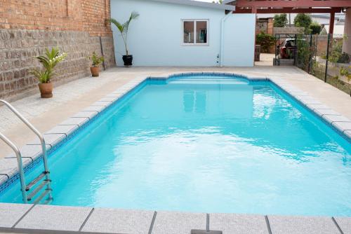 a swimming pool with blue water in a yard at Somptua Garden in Ivato
