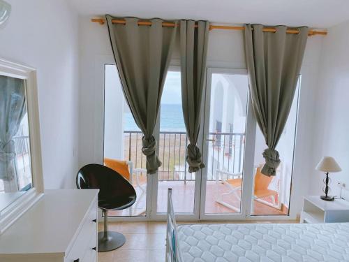 a bedroom with a large window with a view of the ocean at Amazing view in Playa den Bossa in Sant Josep de sa Talaia