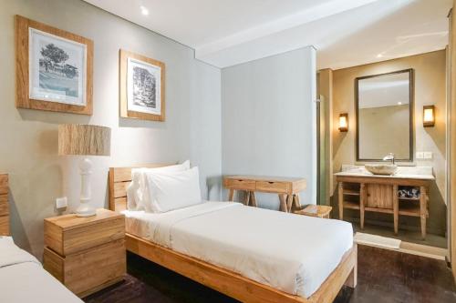a bedroom with a bed and a desk and a mirror at Villa Bima II in Nusa Dua