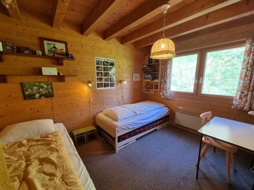 a bedroom with a bed and a table in a cabin at Bachhüs BA1 in Blatten bei Naters