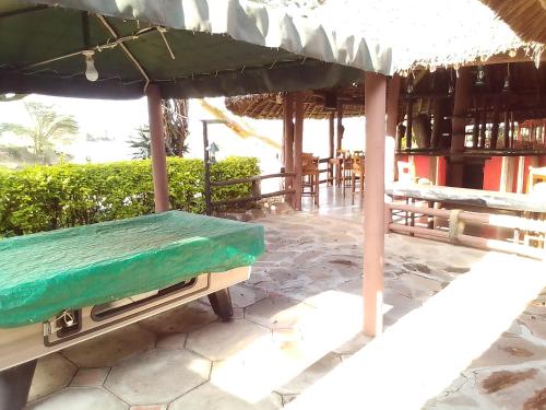 a bench under an umbrella on a patio at Mara River Lodge in Aitong