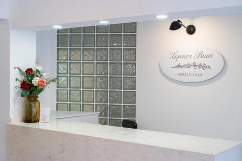 a lobby with a counter with a vase of flowers at Herceg Vila in Trebinje