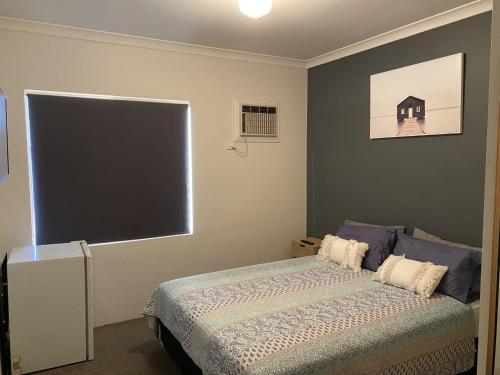 um quarto com uma cama e um grande ecrã em The Piccadilly Hotel em Kalgoorlie