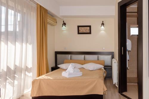 a bedroom with a bed with towels on it at Hotel Grand in Eforie Nord