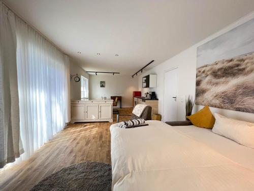 ein Schlafzimmer mit einem weißen Bett und einem großen Fenster in der Unterkunft Kapitänshaus Lassen - Zimmer Atlantis in Westerland