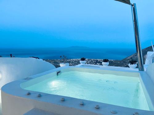 a jacuzzi tub with a view of the ocean at Amphora Villas Santorini Pyrgos in Pirgos