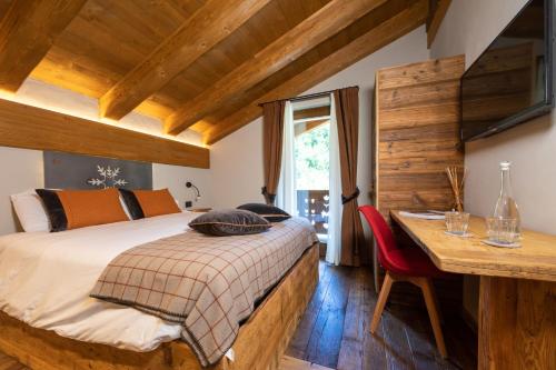 een slaapkamer met een bed, een tafel en een bureau bij La Cascata Chambres d'hôtes in La Salle
