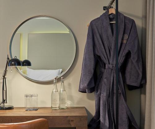 a robe hanging on a wall next to a mirror at Powerscourt Springs Health Farm in Wicklow