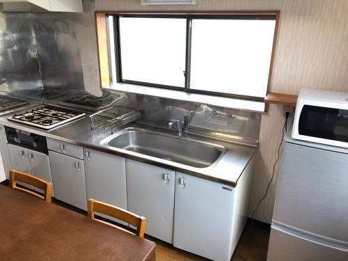 cocina con fregadero, fogones y mesa en 今市STAY - NIKKO private house rental only 5 min to station en Nikko