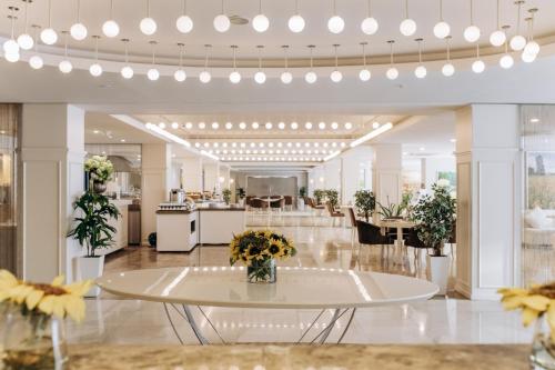 a lobby with a table with flowers on it at Qafqaz Sahil Hotel Baku in Baku