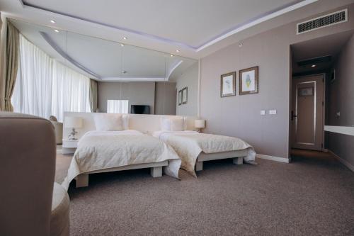 a large bedroom with two beds with white sheets at Qafqaz Sahil Hotel Baku in Baku