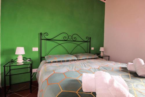 a bedroom with a large bed with green walls at Il casale di Sandra in Chiusi