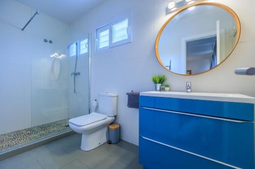 een badkamer met een toilet, een wastafel en een spiegel bij Villa Mi Sol in Torrevieja