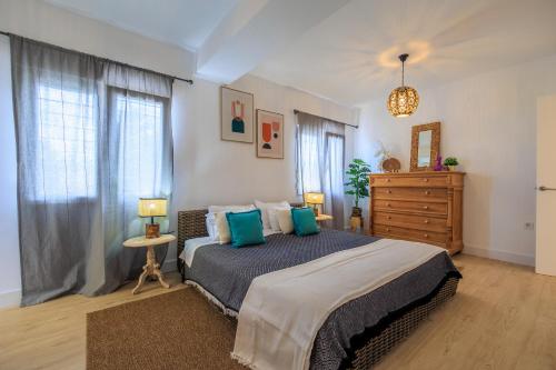 a bedroom with a large bed with blue pillows at Villa Mi Sol in Torrevieja