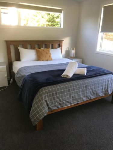 a bedroom with a bed with a blue blanket and pillows at "Great Scott" Great spot your Tekapo Retreat in Lake Tekapo