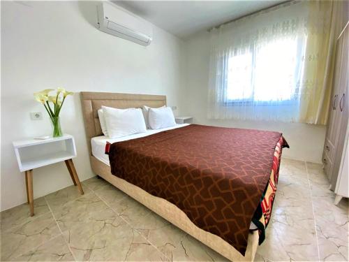 a bedroom with a bed and a vase of flowers at Gurkan Apart Hotel in Dalyan