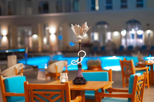 a table with a lamp on it in a restaurant at Millennium Lakeview Hotel in Dubai
