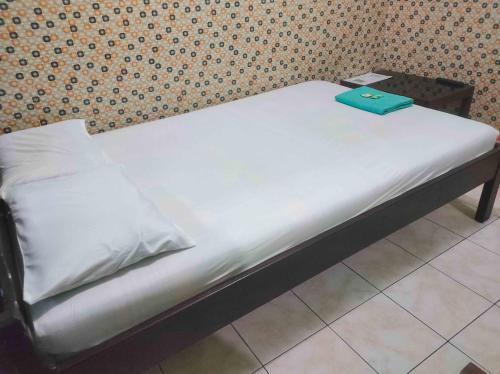 a bed with a green book on top of it at Bayu Murti Inn Kaliurang Yogyakarta RedPartner in Kaliurang