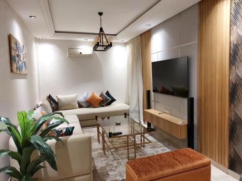 a living room with a couch and a tv at luxury downtown apartment of 80m2 in front of Hassan 2 Mosquē and sea from family , pour famille , INTERDIT COUPLES ARAABIC NON MARIÉ, FORBIDDEN UNMARRIED ARAABIC COUPLES basement car park in Casablanca