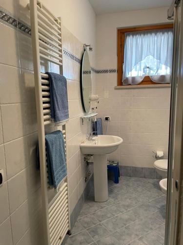 a bathroom with a sink and a toilet and a mirror at Ladi’s B&B in Bardolino