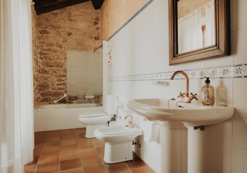 łazienka z umywalką, toaletą i wanną w obiekcie Casas Alexandre w mieście Pontevedra