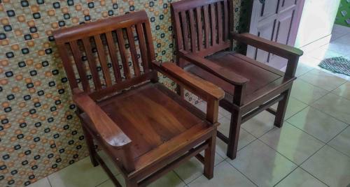 two wooden chairs sitting next to a table at Bayu Murti Inn Kaliurang Yogyakarta RedPartner in Kaliurang