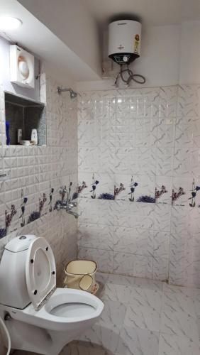 een badkamer met een toilet en een muur met vogels erop bij Nath's Residency in Puri