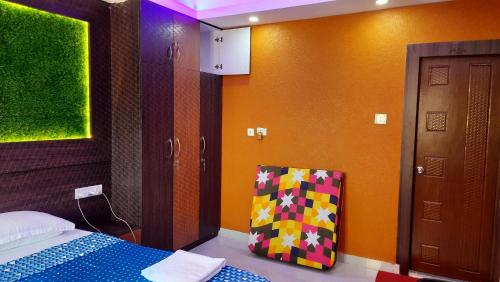 a bedroom with a bed and a colorful wall at Nath's Residency in Puri
