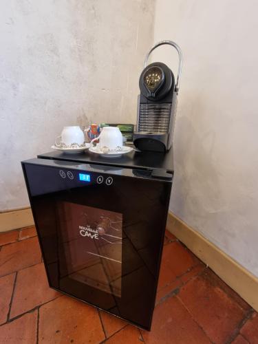 un téléphone assis au-dessus d'une table avec des tasses et des soucoupes dans l'établissement Au petit familistère Landrecies, L'Authentique., à Guise