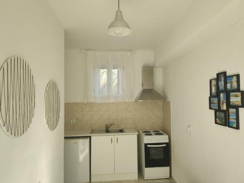 a white kitchen with a sink and a stove at Katerina & Joanna Adamas Studio Milos in Adamas