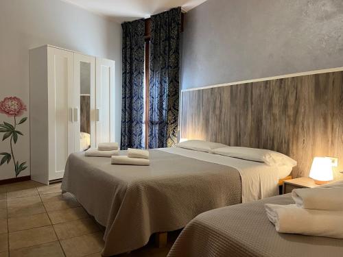 a room with two beds and two tables with towels at Hotel Renata in Lazise