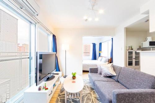 a living room with a couch and a tv at EVE in Sapporo