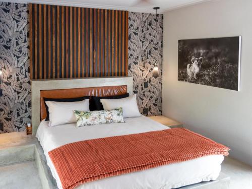 a bedroom with a bed with a red blanket at Muunga Bush Lodge & Spa in Hoedspruit