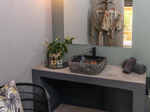 a bathroom counter with a sink and a mirror at Muunga Bush Lodge & Spa in Hoedspruit