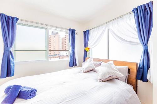 a bedroom with a large bed with blue curtains at EVE in Sapporo