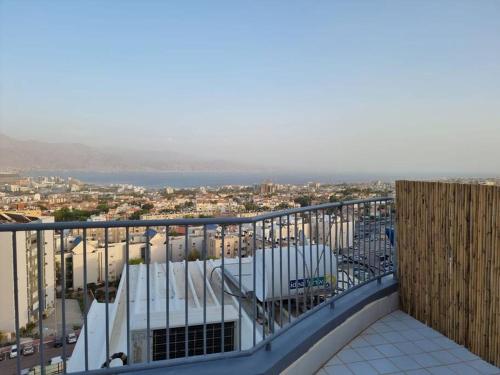 een balkon met uitzicht op de stad bij דירת זוּגַג מפנקת עם מרפסת משגעת ונוף למפרץ. in Eilat