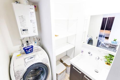 a laundry room with a washing machine and a sink at EVE in Sapporo