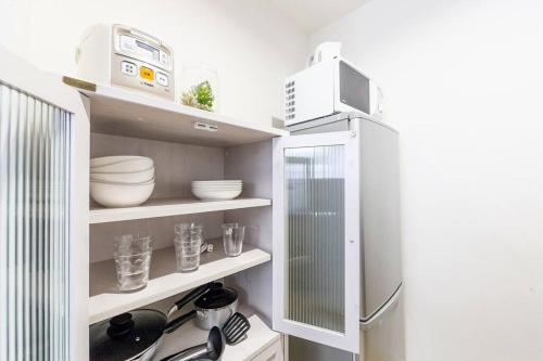 a kitchen with white shelves and a refrigerator at EVE in Sapporo