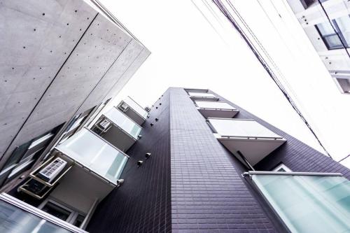 a tall brick building with windows on the side of it at EVE in Sapporo
